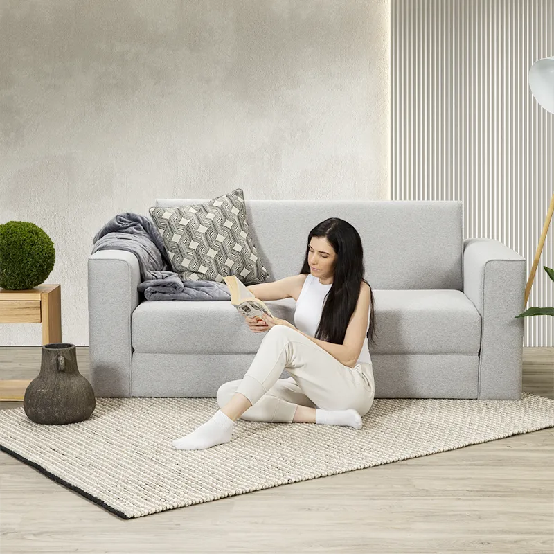 A young woman reading a book on a new Zeek sofa bed.