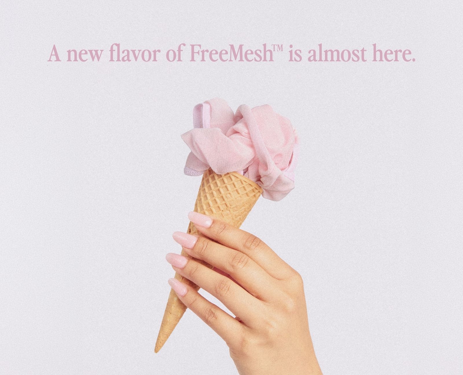 Hand holding a pink ice cream cone against a light background.