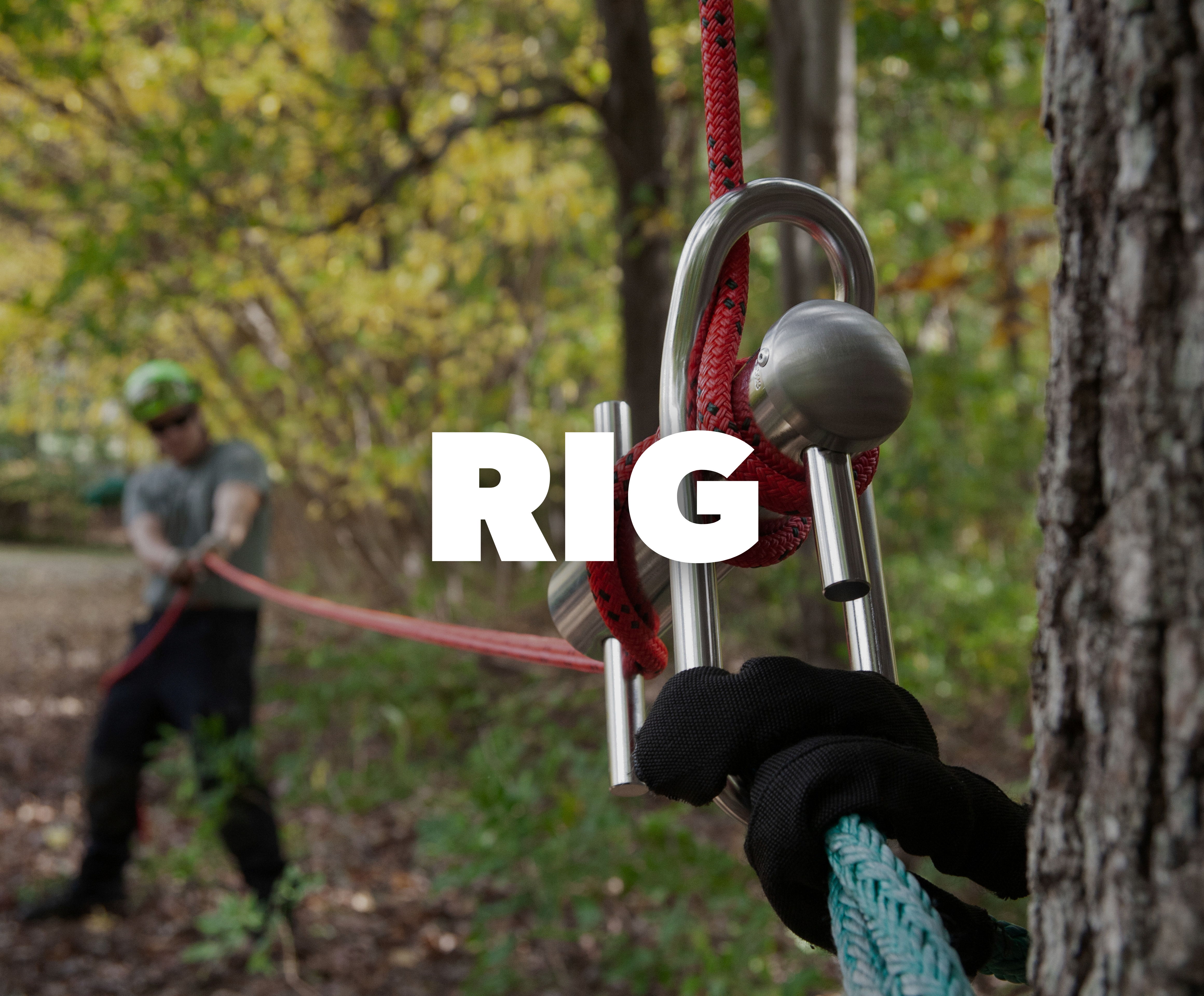 A climbing rig with a person pulling a rope in a forest setting.