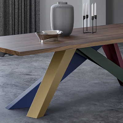 Modern table with colorful legs, vase, and decorative items on top.