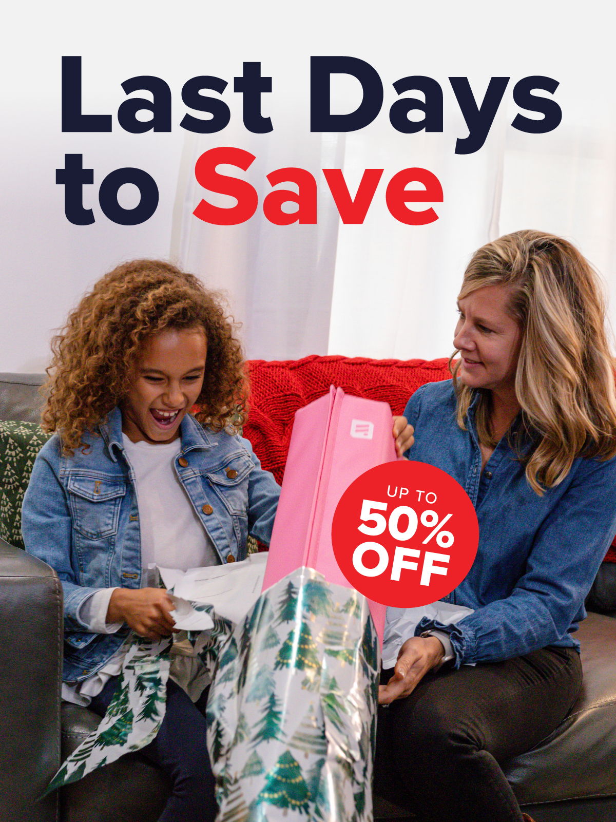 Two women joyfully unwrap a gift with a promotional message about savings.