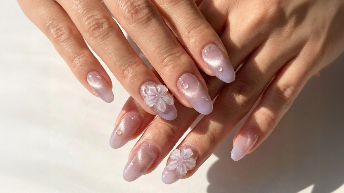 Hands showing a complete set of EyeCandys handmade press-on nails in soft blush with shimmer detail after a clean home application