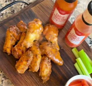 Saucy chicken wings served with celery sticks and dipping sauce. | View this post on Tastefully Simple's Instagram. 