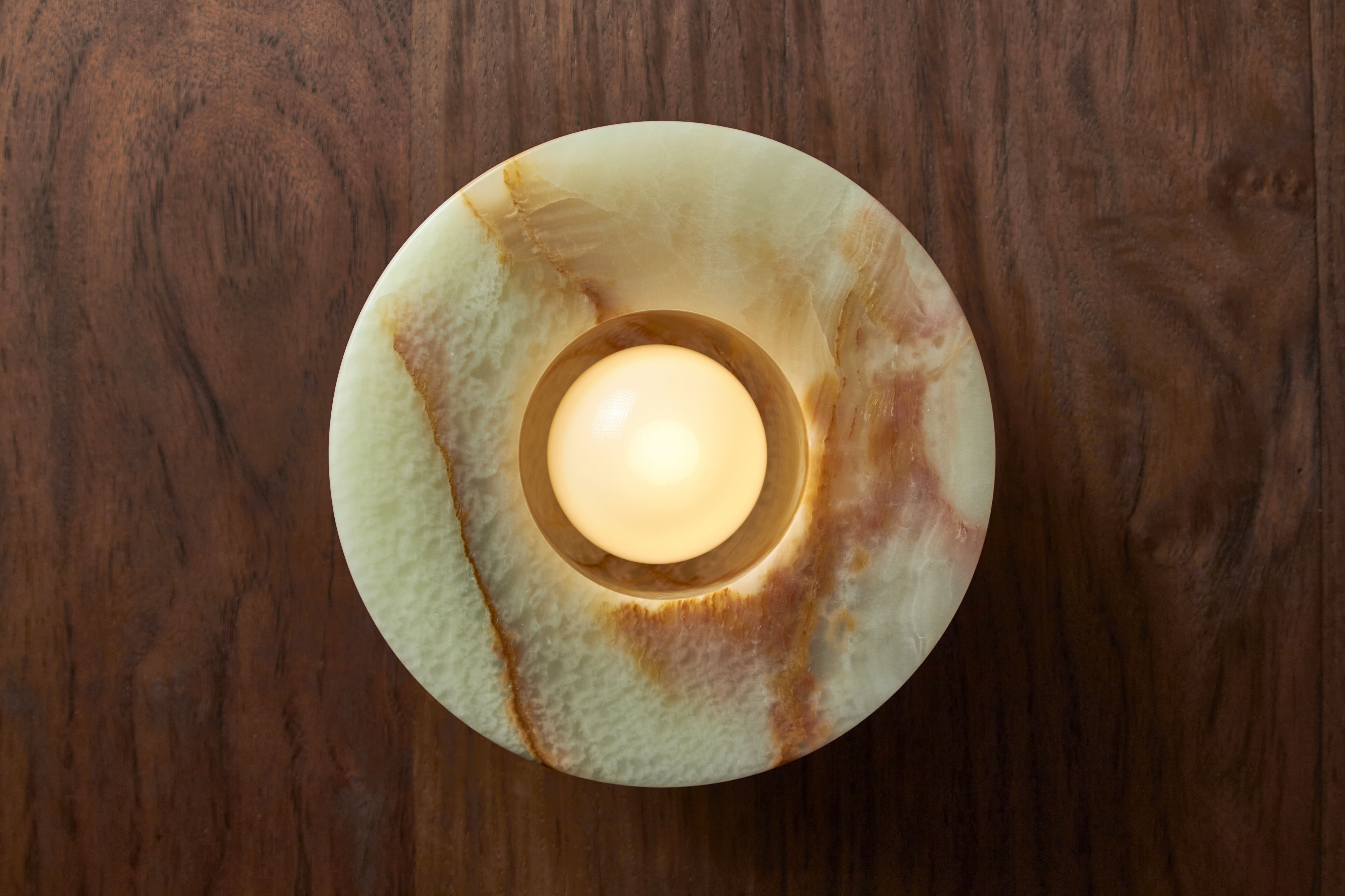 Aurelia Surface Sconce on a dark wooden surface