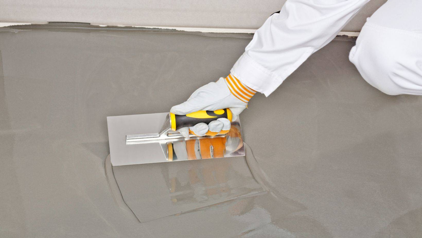 liquid self-leveling compound being applied on a floor surface