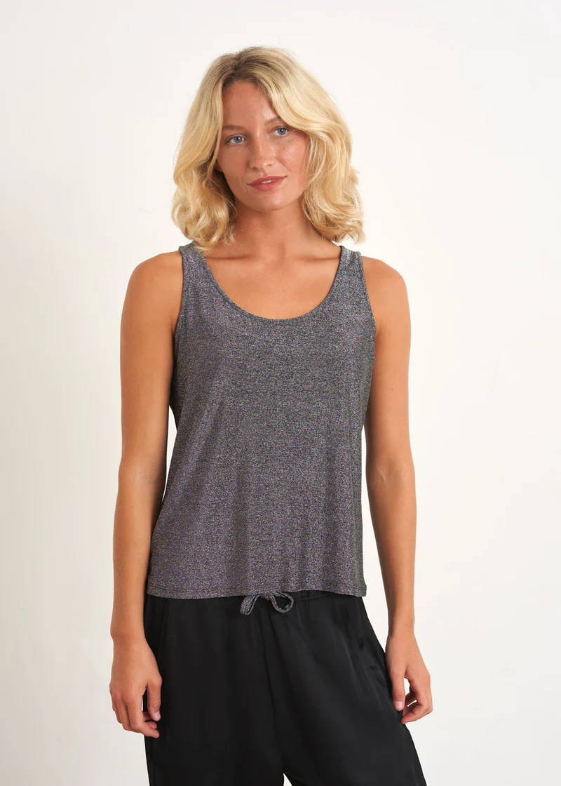 A model wearing a sleeveless grey sparkly top with black trousers