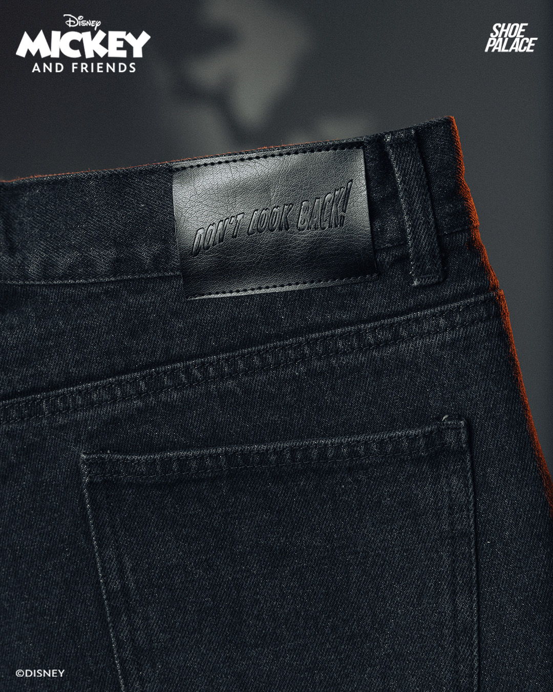 Black jeans with Mickey and Friends branding on the label.