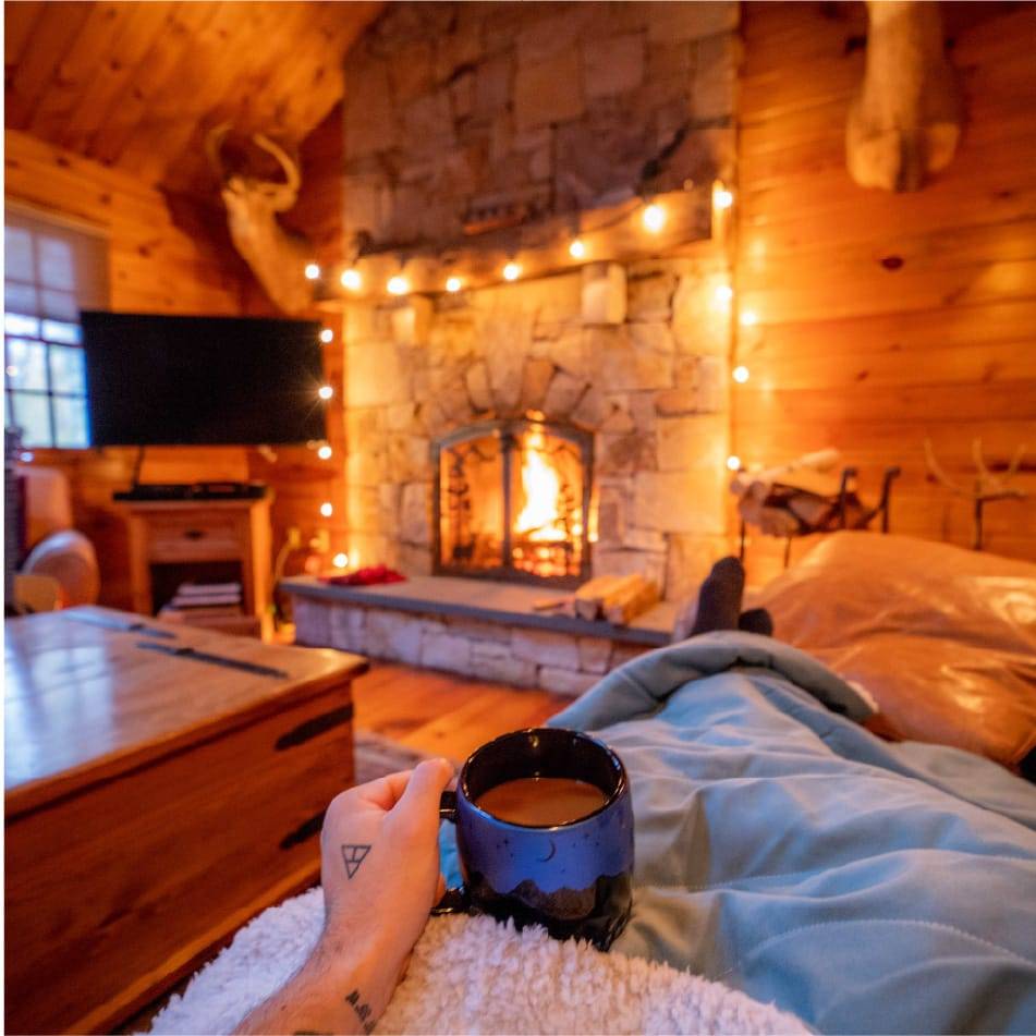 Person sitting on the couch under a sherpa fleece blanket watching a movie