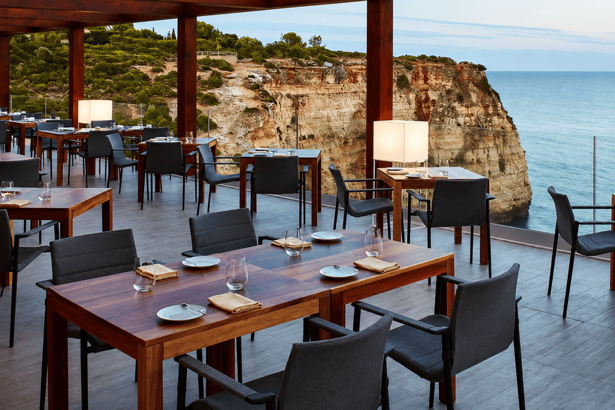 Coastal restaurant patio with movable outdoor dining tables and commercial chairs arranged for flexible seating