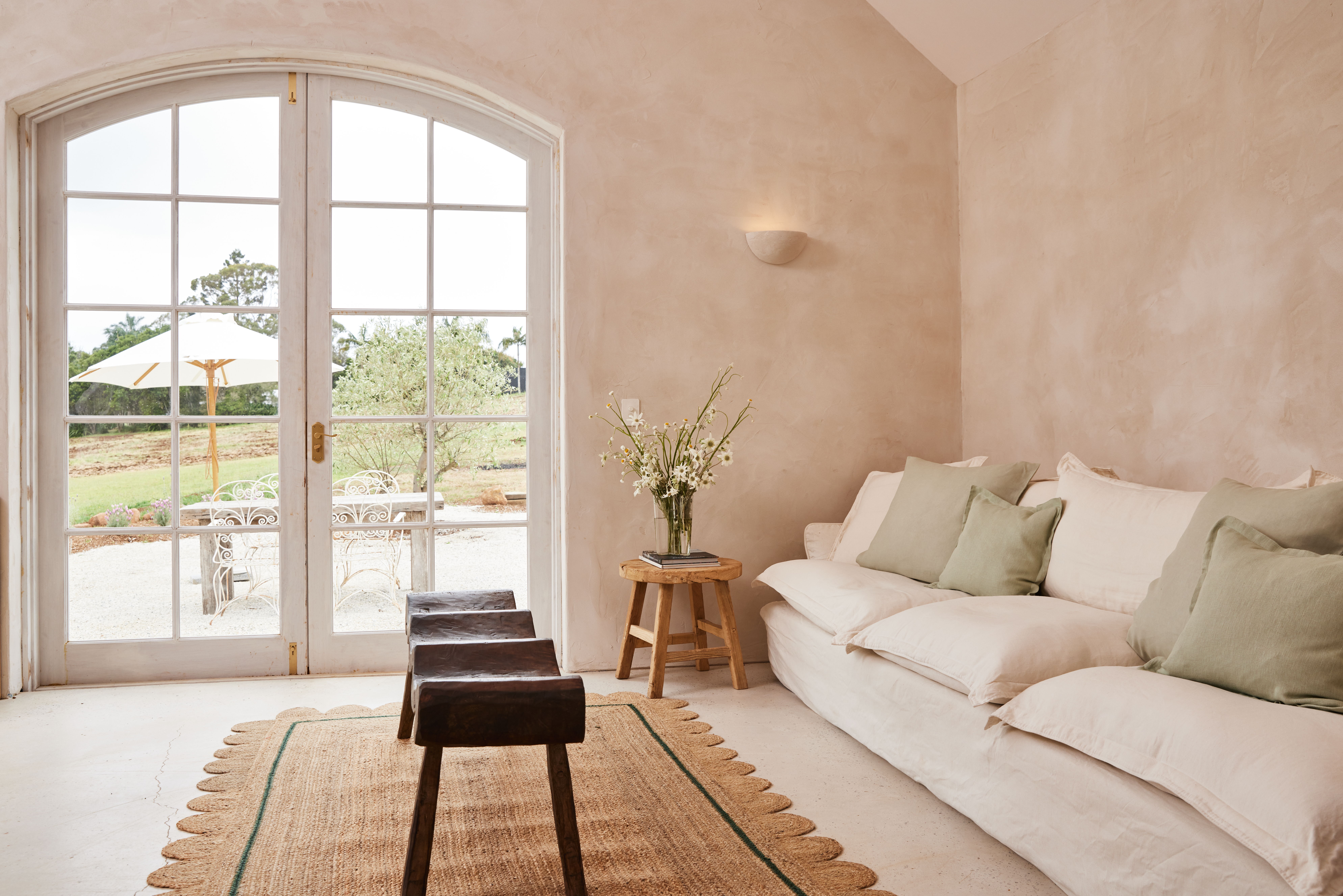 Rustic french style living room with a sofa, wooden decor and a plaster wall light