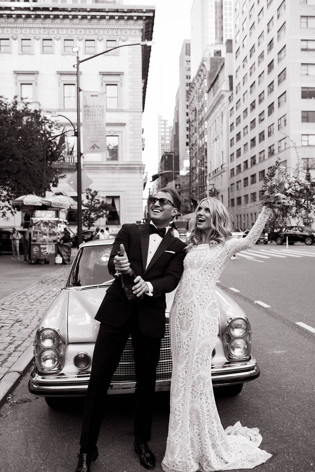 Bride and Groom popping champagne in New York busy street