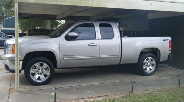 Silver GMC Sierra pickup side view with train horn install