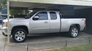 Silver GMC Sierra pickup side view with train horn install