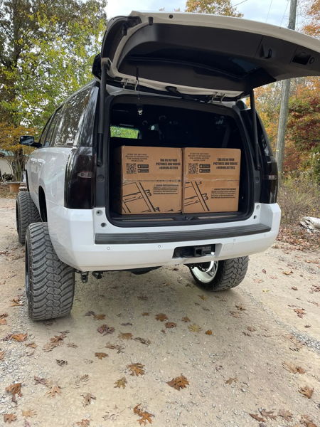 Open rear cargo area of Addison's 2015 Chevy Tahoe with HornBlasters boxes loaded inside, install photo 3