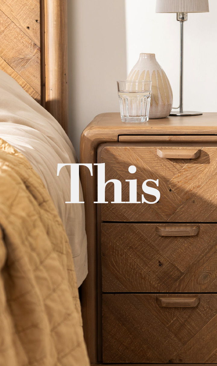 A cozy bedroom corner with a nightstand, lamp, and decorative items.