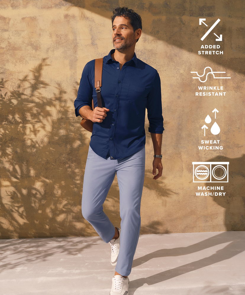 Man walking in casual attire against a neutral background.