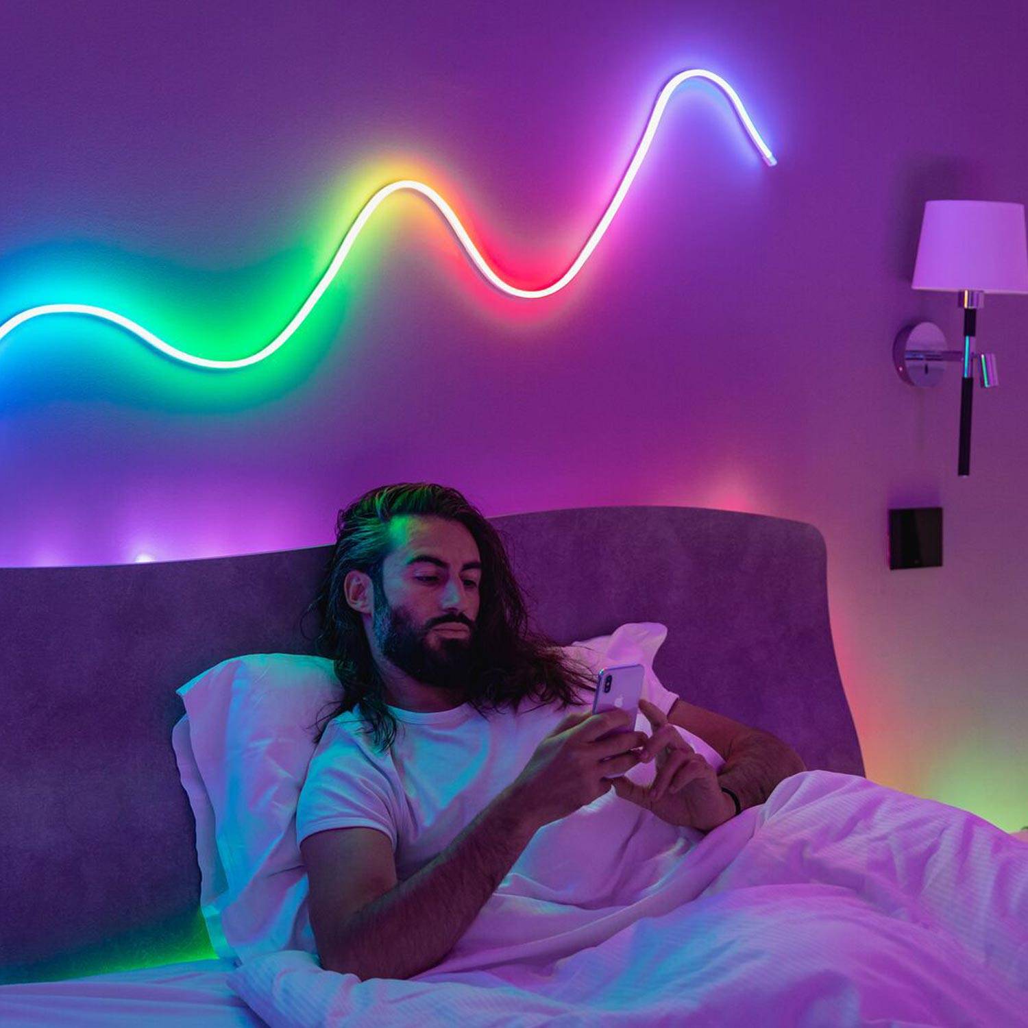 Twinkly Flex in a curved line abouve a man in bed.