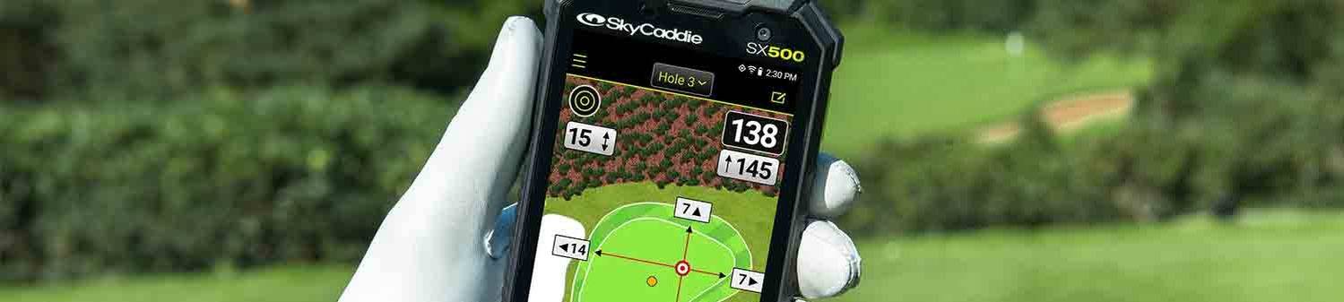 The SkyCaddie SX500 golf GPS handheld in a golfers hand on the course
