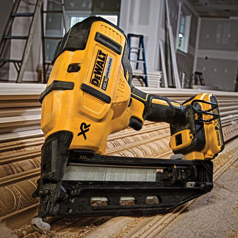 A yellow and black cordless nail gun on wood panels.