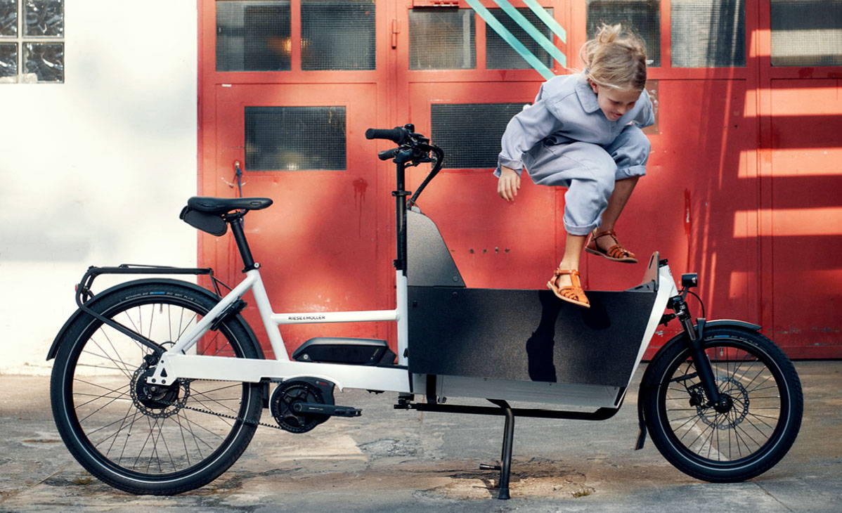 A girl jumps out of the RIese & Muller Transporter2 65 cargo e-bike