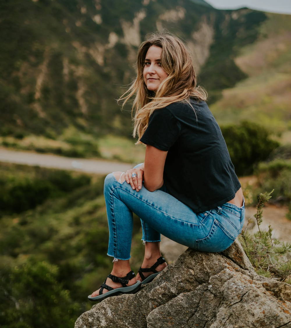 woman on rocks wearing stylish sandals that are comfortable