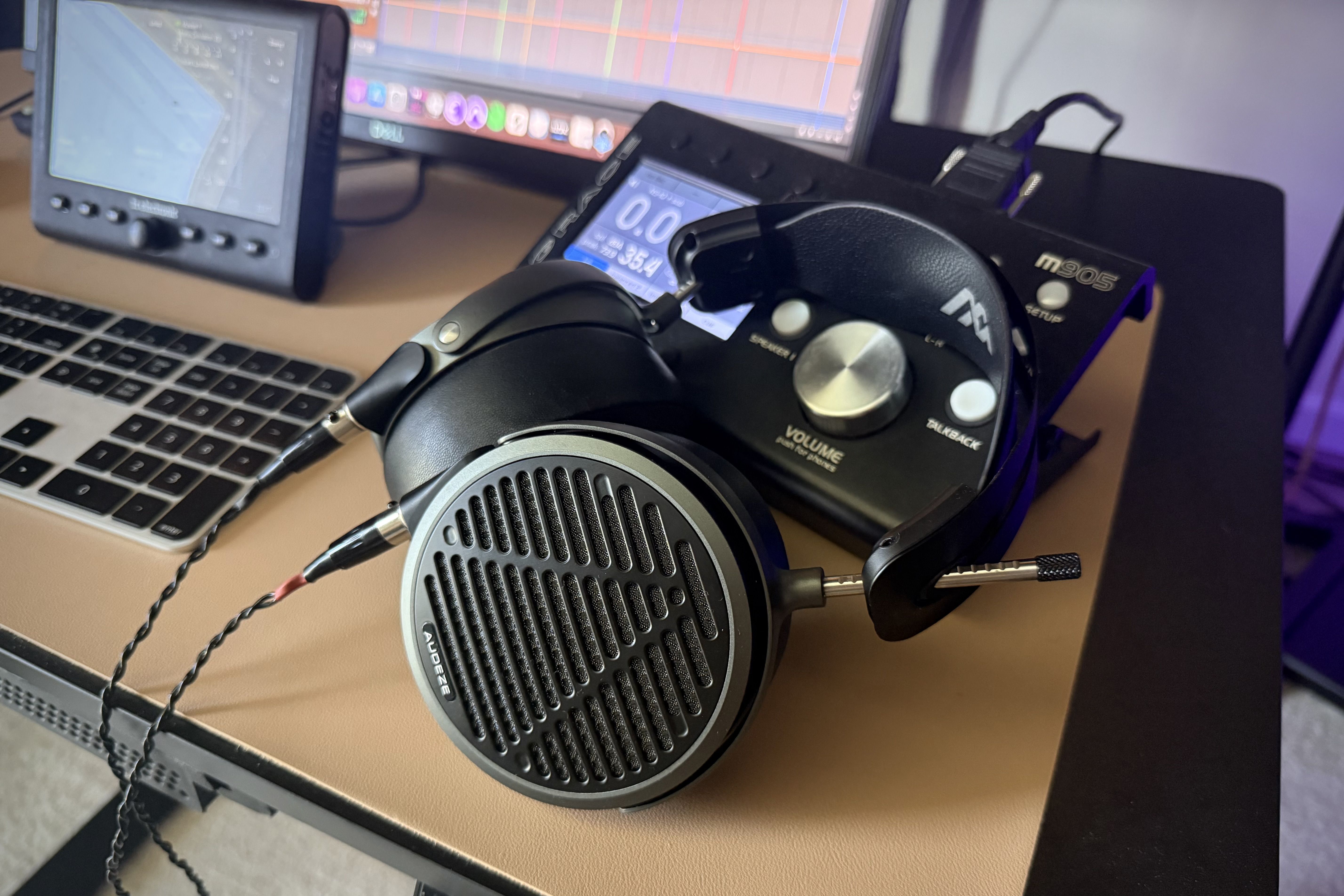 Audeze MM-500 headphones laying on table in front of an amp