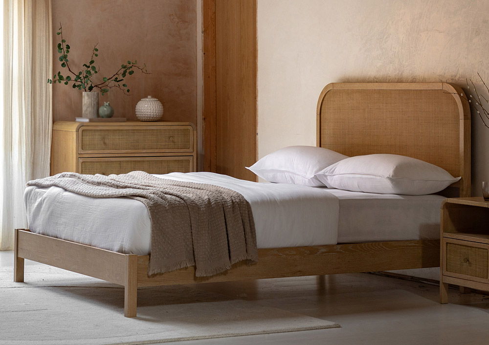 A cosy bedroom with a wooden bed and soft linens.