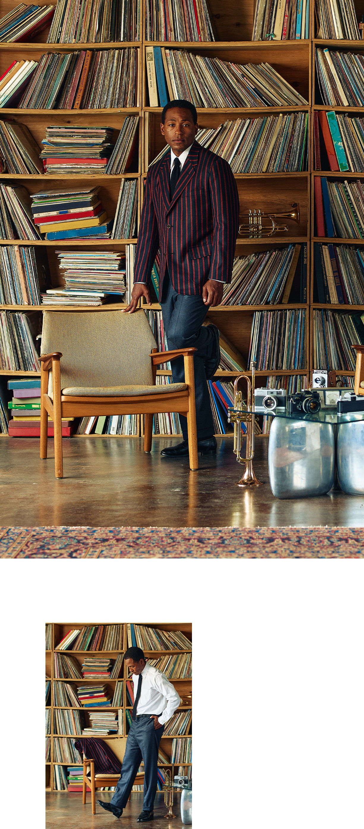 Person in a striped suit standing near a large vinyl record collection.