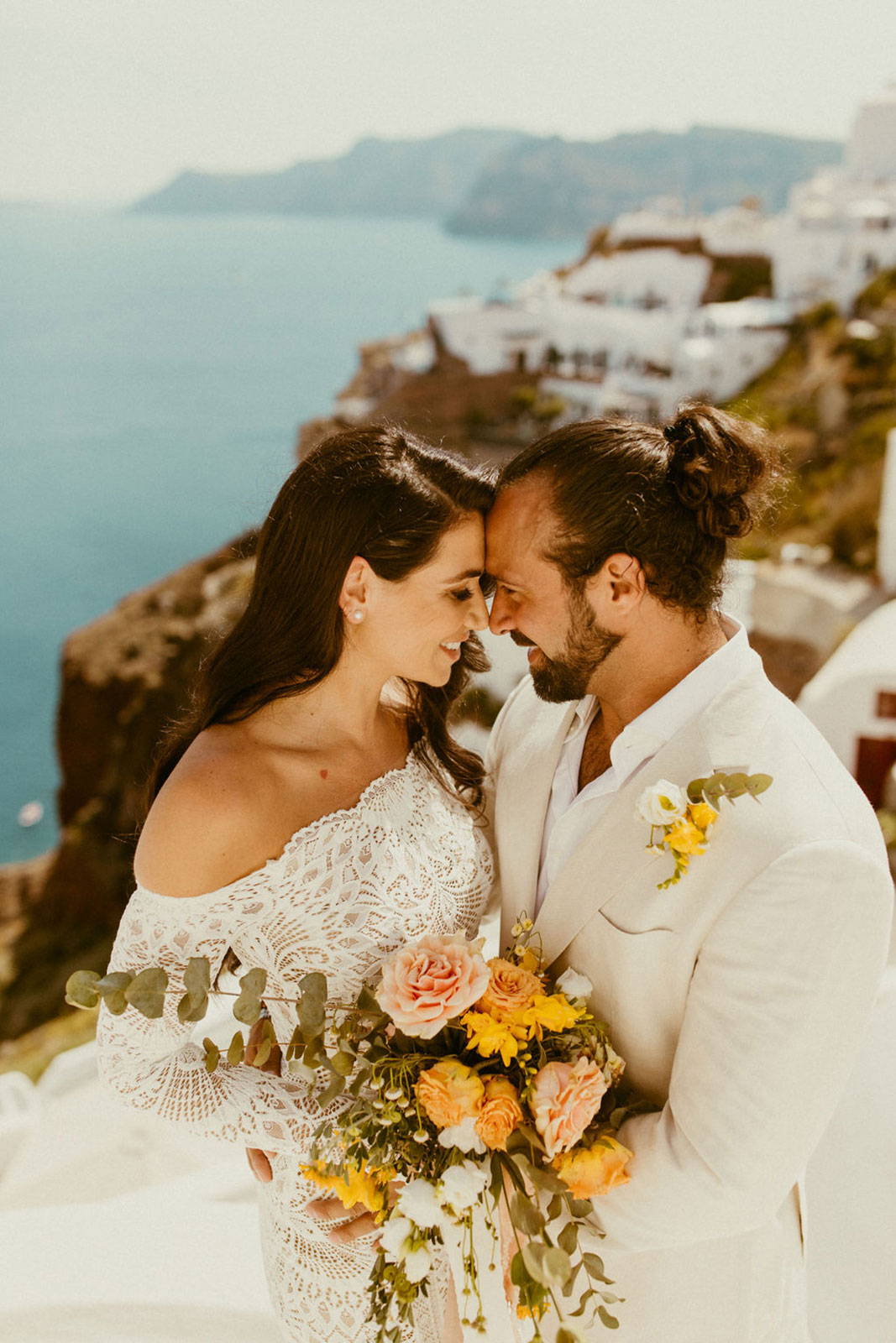 La mariée et le marié se regardent avec un bouquet.