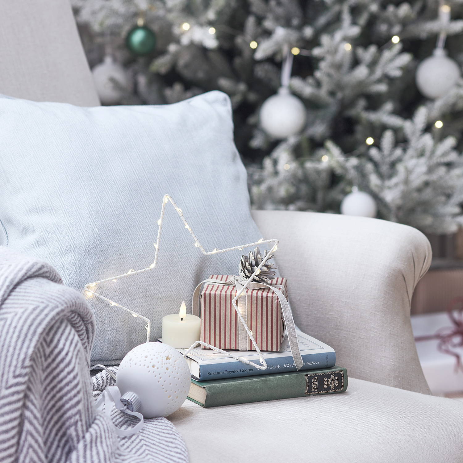 A small star light with a present on an armchair in a Christmas living room.