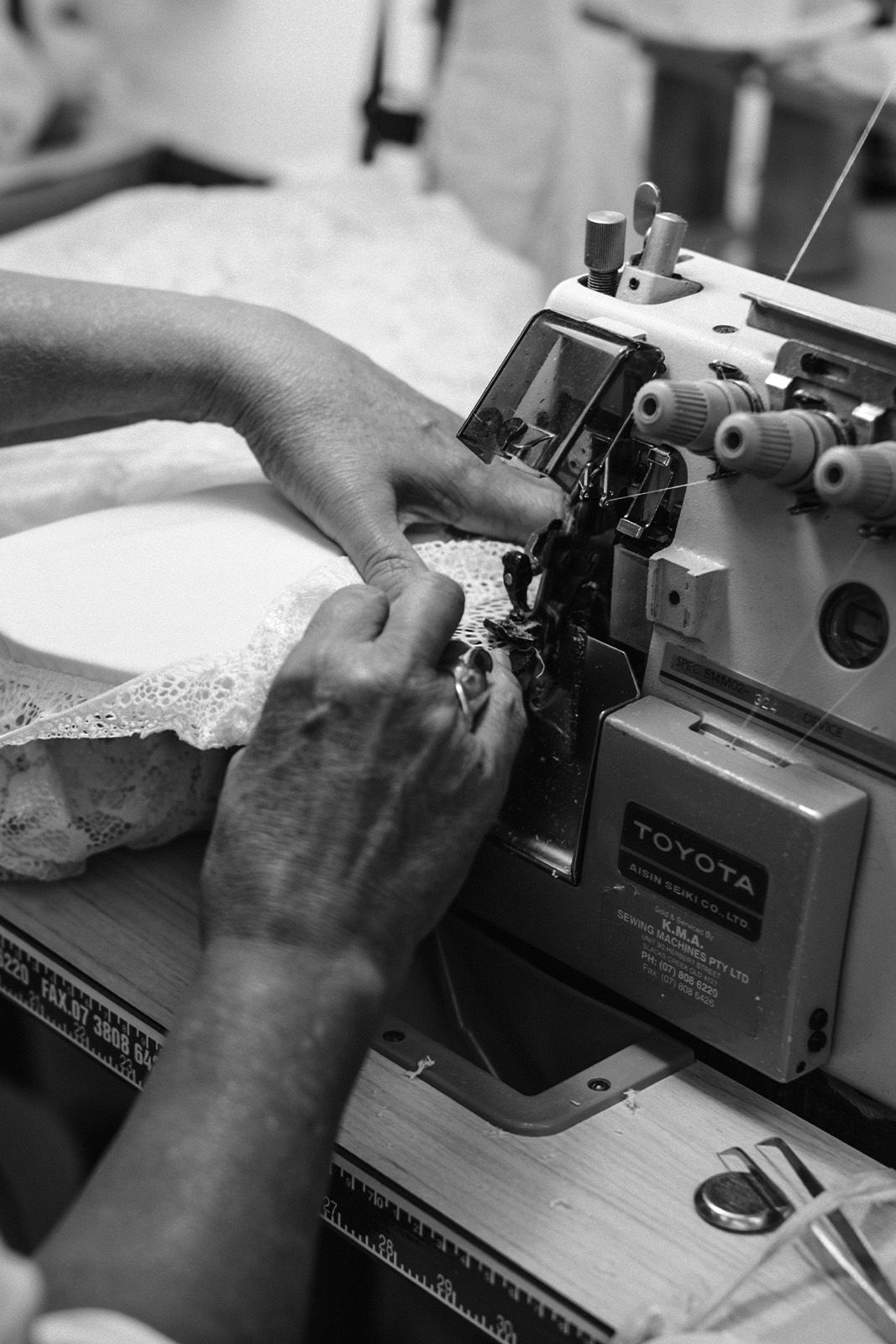 A person sewing with a sewing machine and lace fabric.