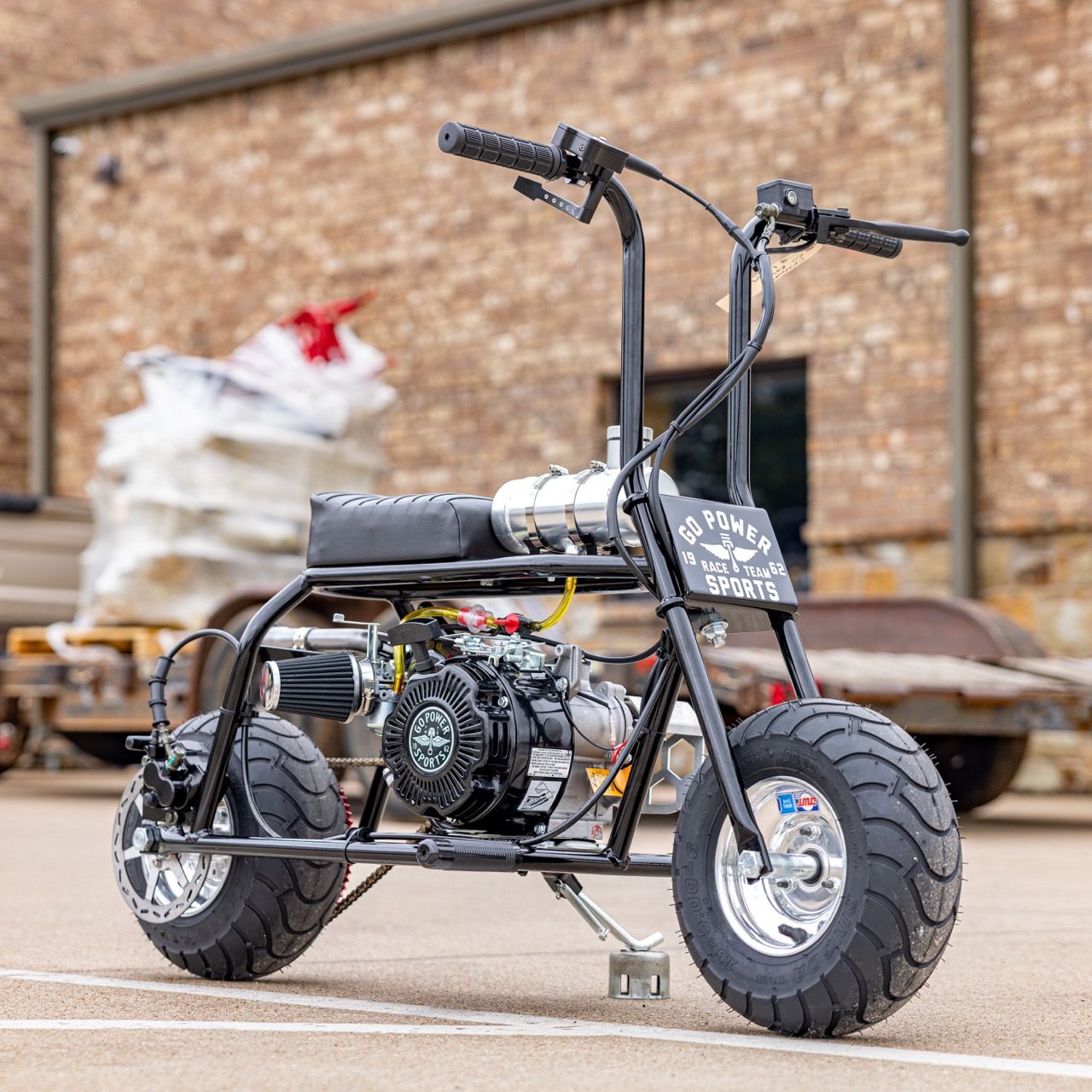 A small black motorized bike with large tires parked on a concrete surface.