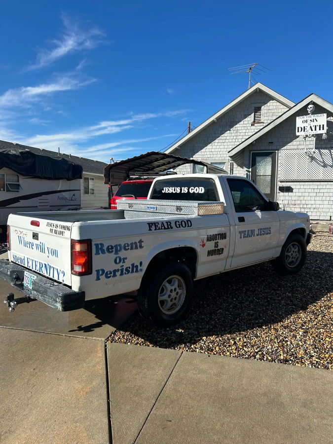Rear three-quarter Miranda's 1994 Dodge Dakota pickup with religious decals on tailgate rear window and sides photo 2