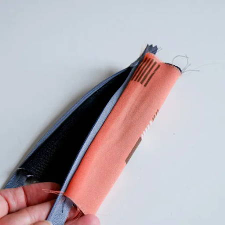A piece of lining fabric sewn to both sides of a blue zipper