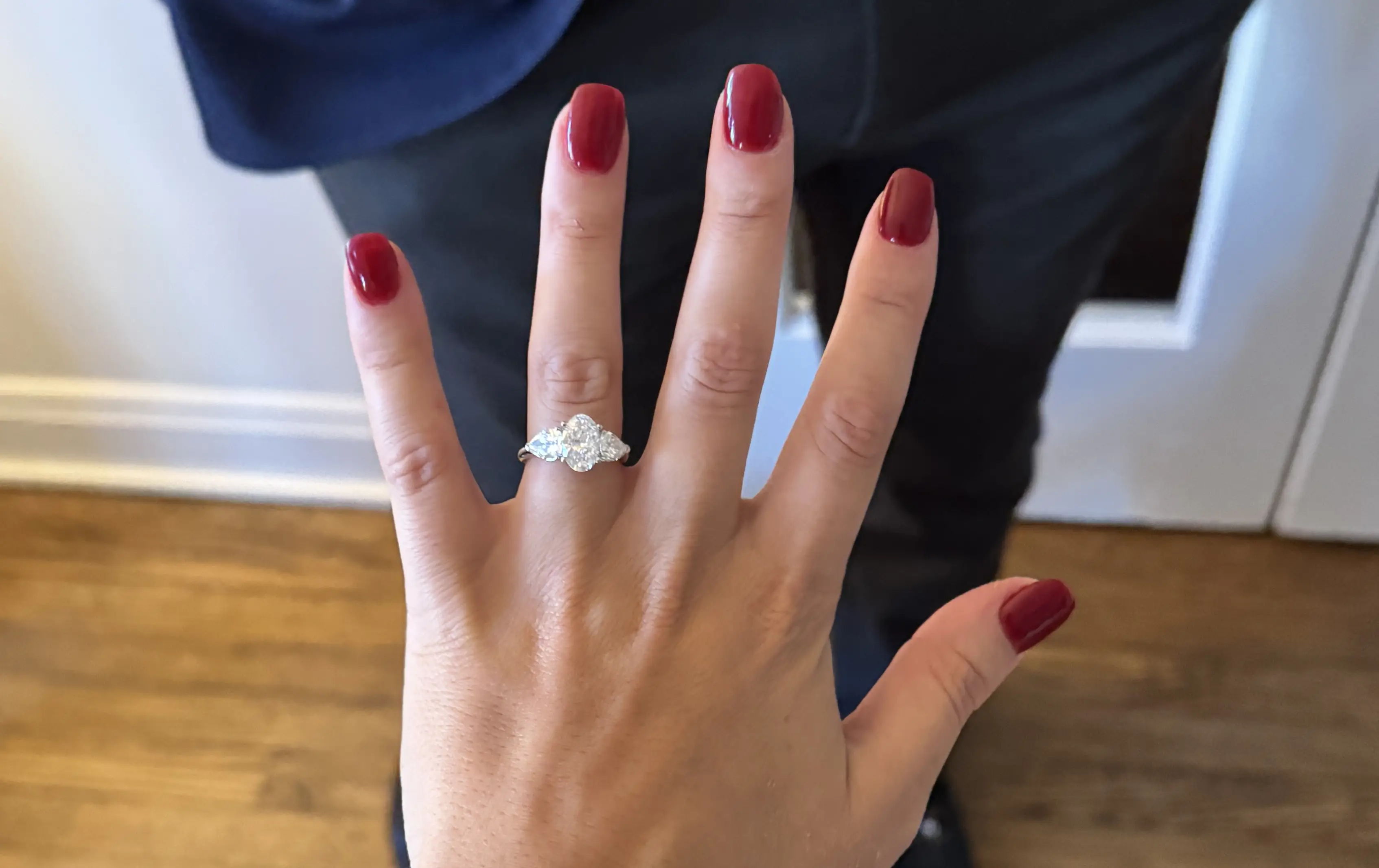 3 stone diamond engagement ring on woman's finger