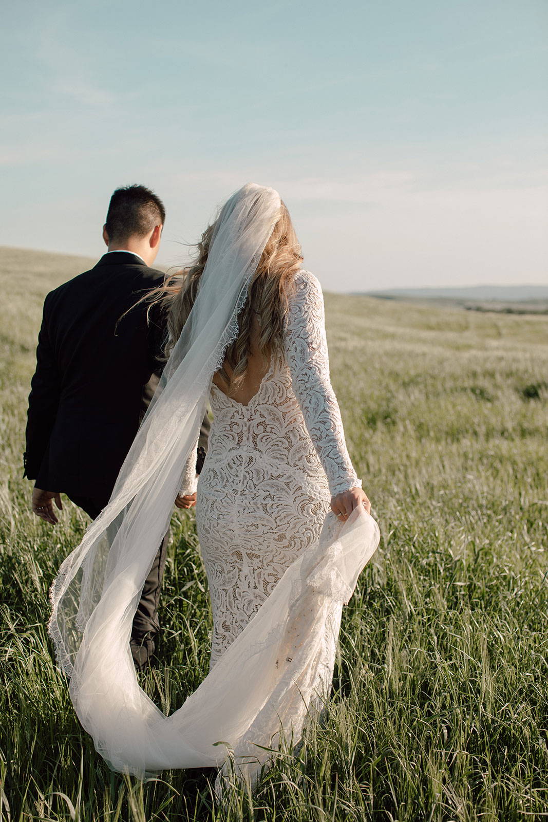 Bride and Groom walking in field
