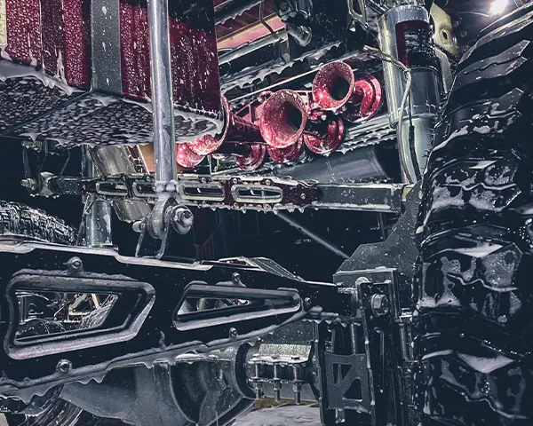 Close-up of burgundy train horns mounted under lifted truck