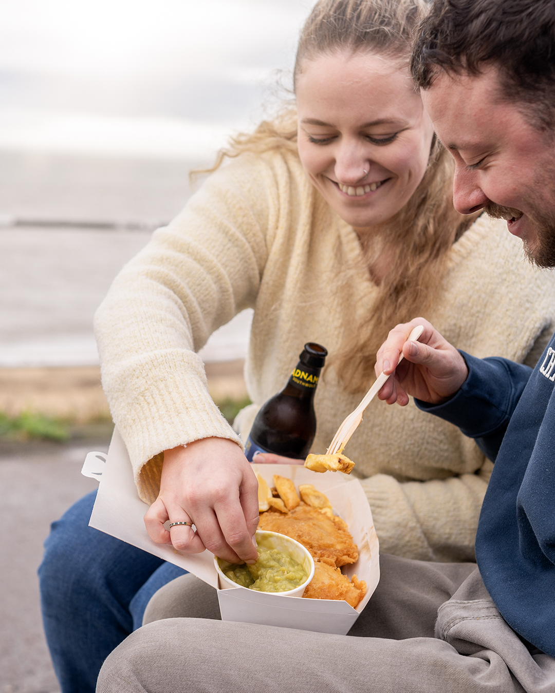 sharing food by the water, enjoying each other's company.