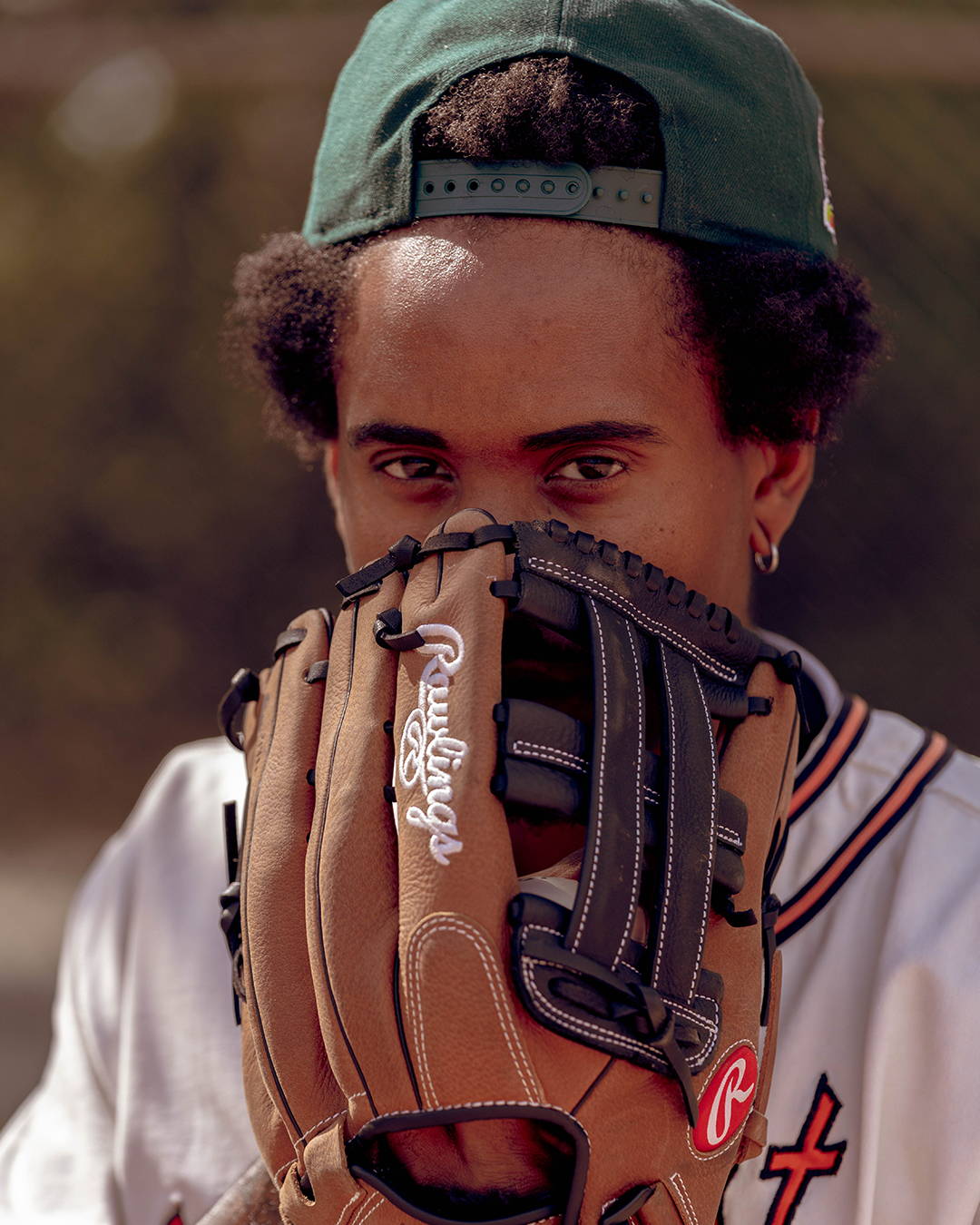 male model with a baseball glove to his mouth