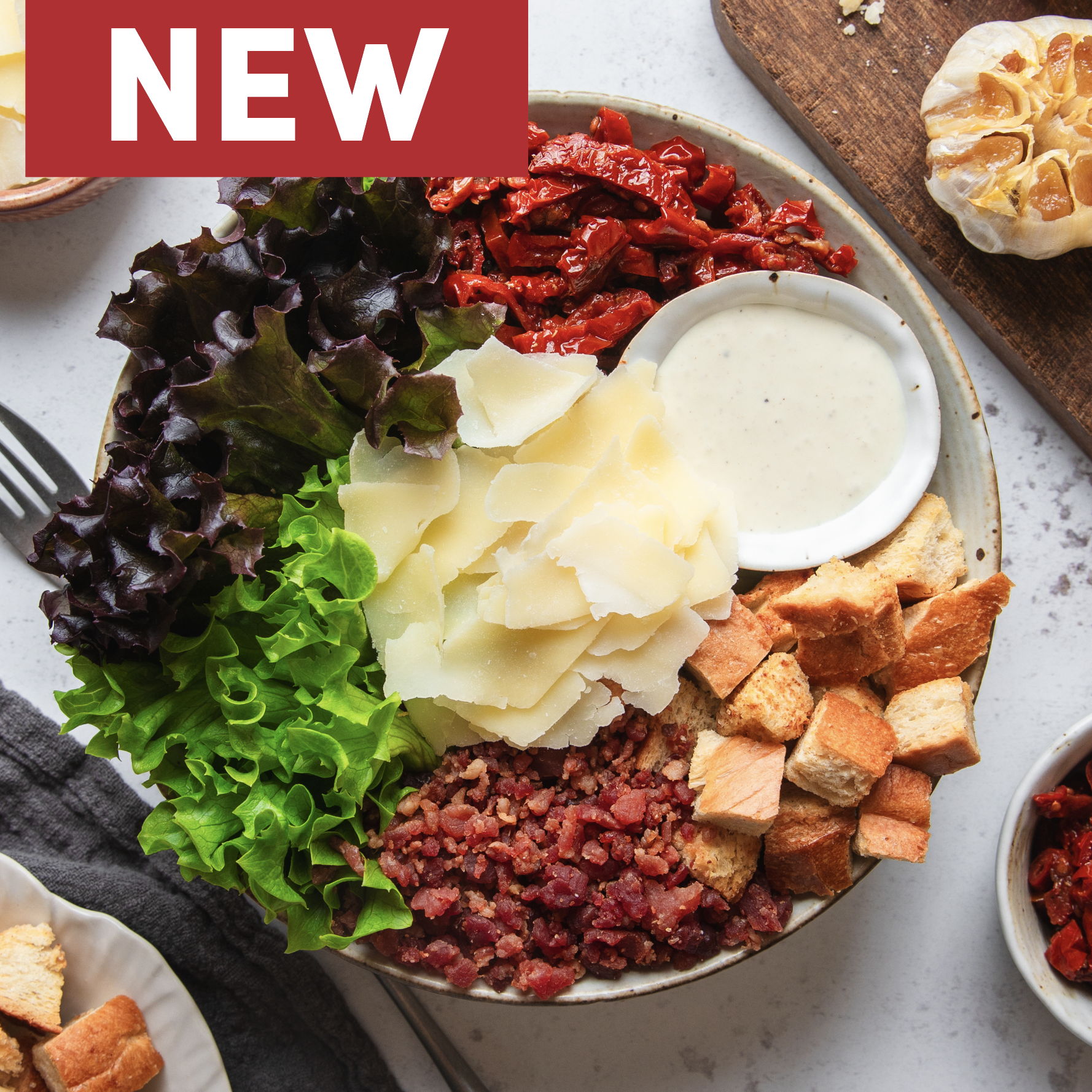 Bowl with lettuce, croutons, sun-dried tomatoes, and dressing, labeled 