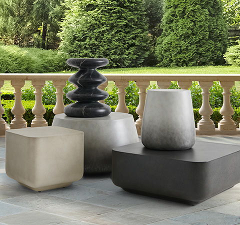 Three decorative outdoor stools in various shapes and colors on a patio.