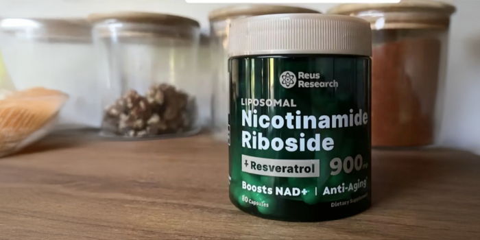 A jar of Nicotinamide Riboside on a wooden surface with jars in background.