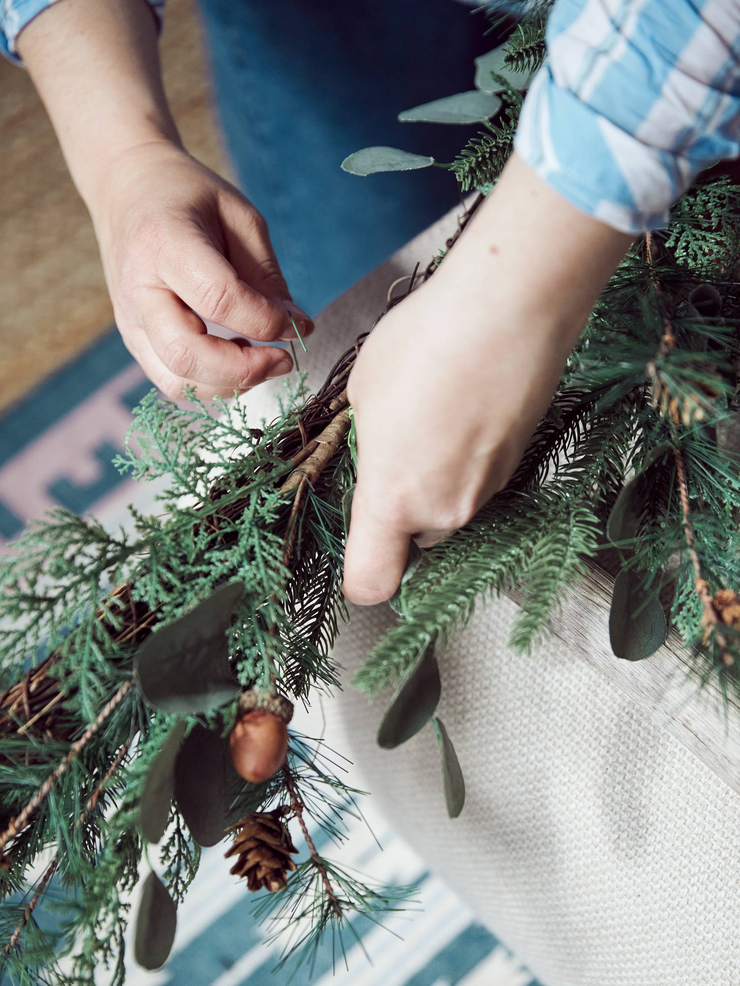 Person attaching the Christmas garland to the ladder.