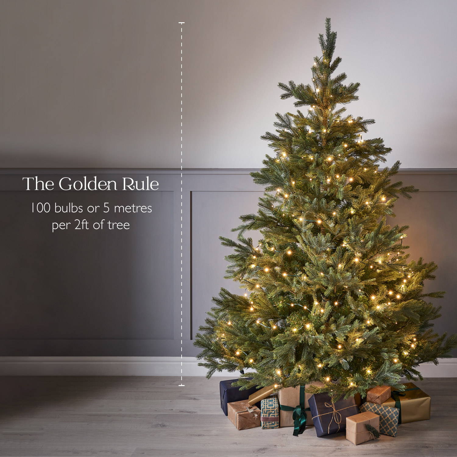 Golden Rule - 100 bulbs of 5m of lights per 2ft of tree. An artificial Christmas Tree dressed with warm white Christmas trees and presents wrapped underneath.