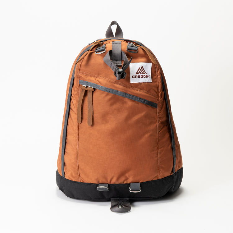 Brown backpack with black bottom and front zipper pocket.