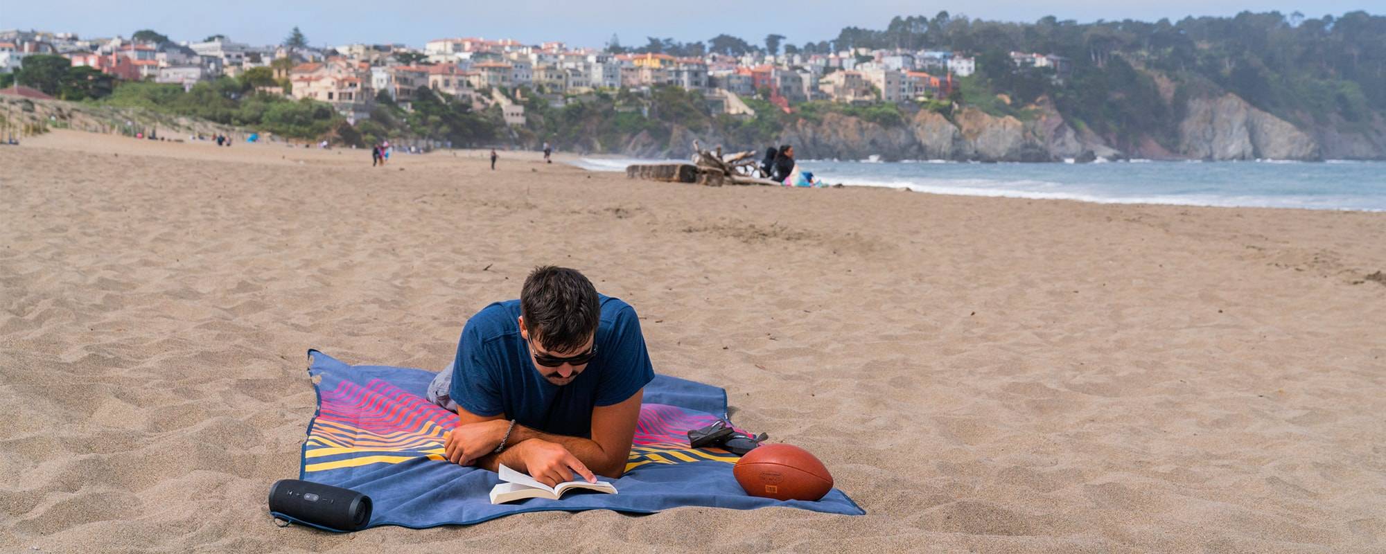 Man laying on beach on towel