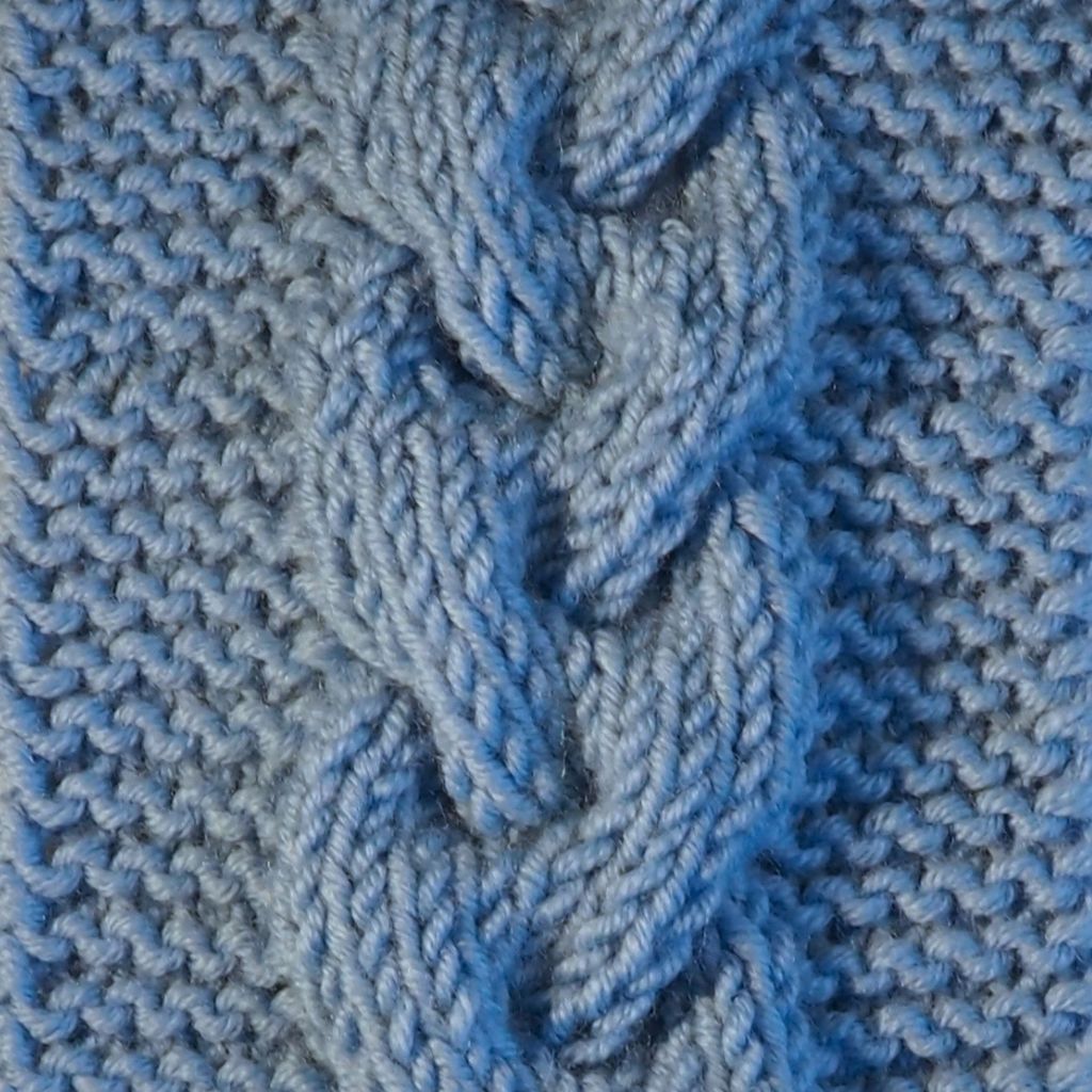 Detailaufnahme eines geflochtenen Zopfes aus blauem Garn.
