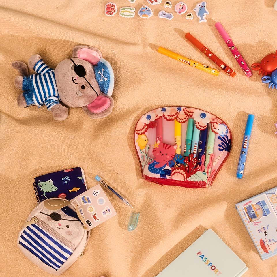 Colorful stationery and plush toys arranged on a soft surface.