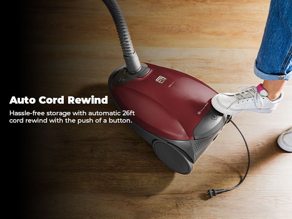 Vacuum cleaner with auto cord rewind feature and a person’s foot nearby.