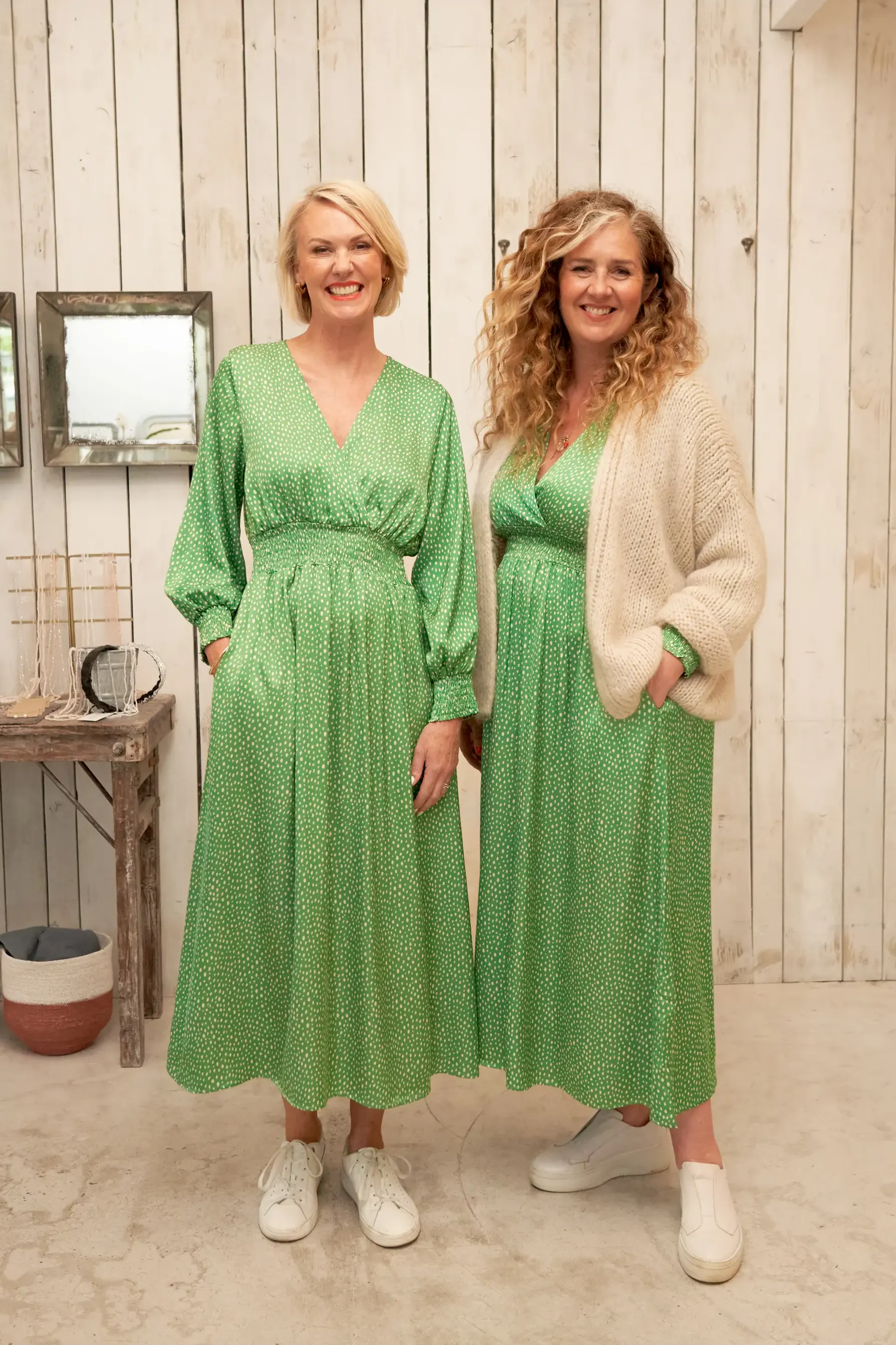 Two woman wearing green polkadot dresses with white pumps